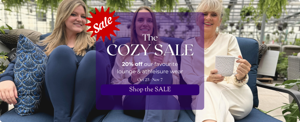 3 smiling women of various ages sit in a plant-filled greenhouse. They're wearing comfortable, soft clothing in shades of cream and navy. Text reads 'The COZY SALE. 20% off our favourite lounge & athleisure wear Oct 25 - Nov 7' Shop the SALE.